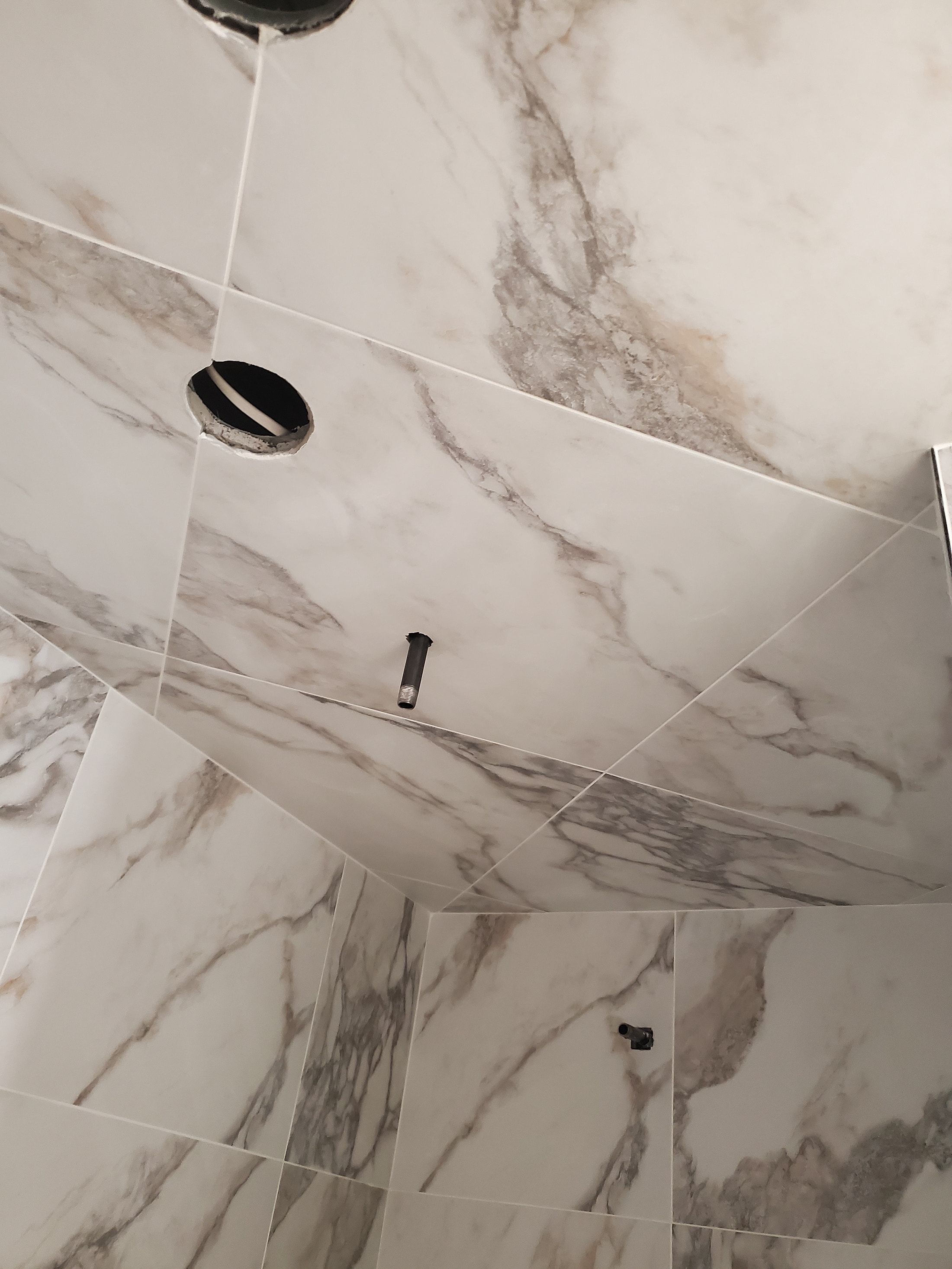 Calacatta marble shower wall with bookmatched veining, premium natural stone installation