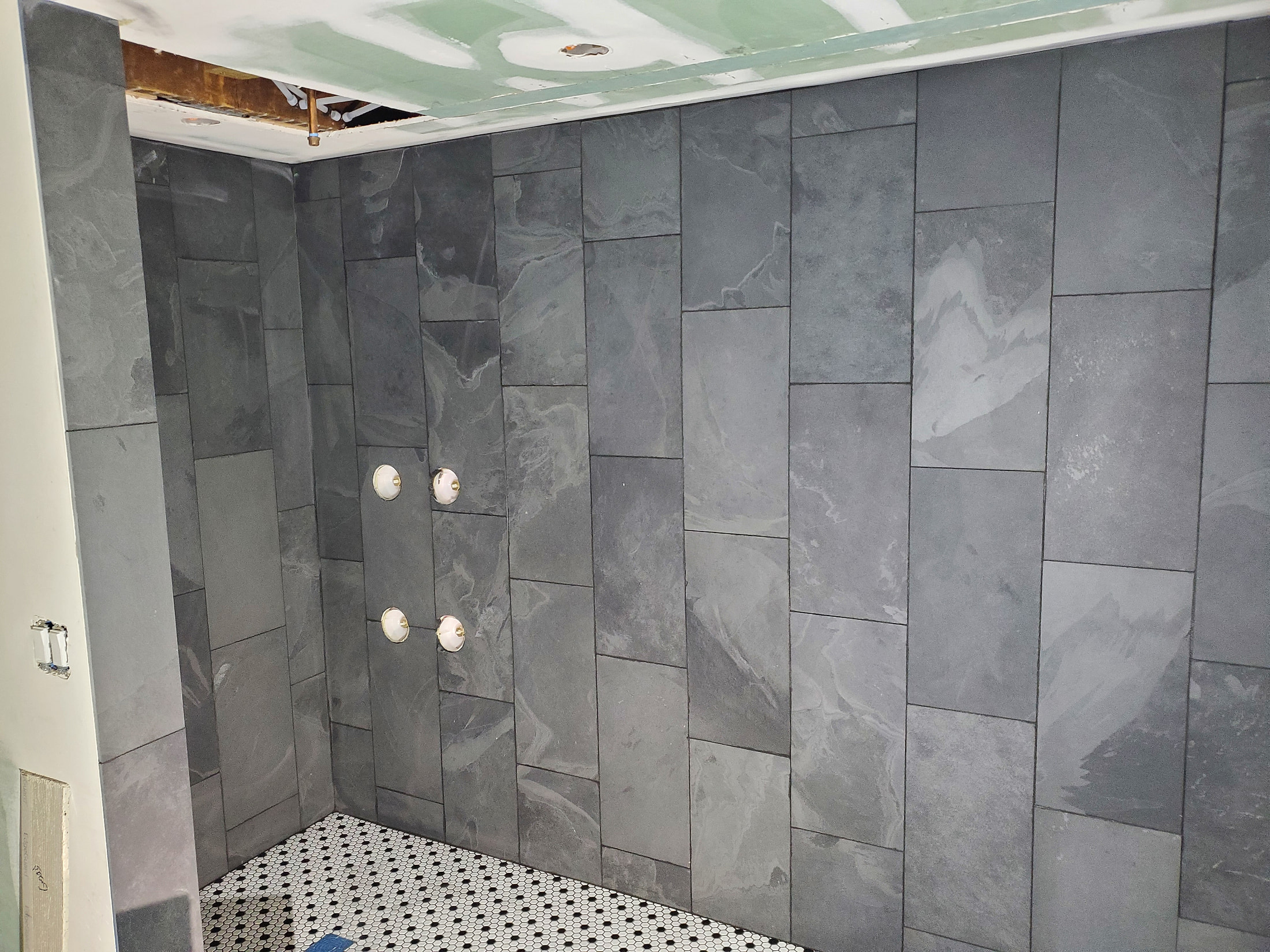 Slate-look porcelain shower walls with white penny tile floor, custom built
